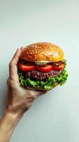 Person holding hamburger in hand photo