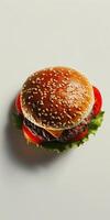 Hamburger with lettuce and tomato on white surface photo