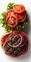 Delicious hamburger with tomatoes, lettuce, and onions photo