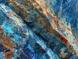 Close up of rock face with blue and orange paint photo