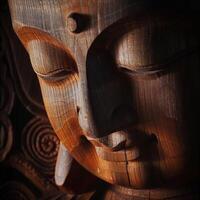 Close Up of a Wooden Carving of a Buddha Face photo