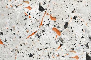 Marble surface with orange and black speckles photo