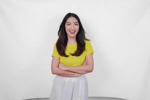Confident Asian woman standing with arms folded and smiling at camera, isolated over white background. photo