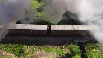 Spectacular steam train filmed in motion by a drone. Ancient locomotive that pulls carriages. train that runs on coal, snorts and makes a lot of smoke. Event where a historic means of transport passes video