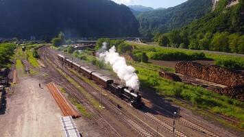 Spectacular steam train filmed in motion by a drone. Ancient locomotive that pulls carriages. train that runs on coal, snorts and makes a lot of smoke. Event where a historic means of transport passes video
