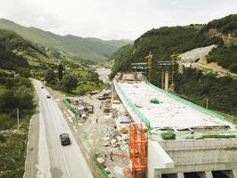 Kazbegi, Georgia - 7th july, 2024 - aerial view cranes and bridge foundation pillars on construction site of new highway road project built by chinese builders.Avalanche bypass tunnel.Tbillisi - Lars photo