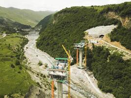 Kazbegi, Georgia - 7th july, 2024 - aerial view cranes and bridge foundation pillars on construction site of new highway road project built by chinese builders.Avalanche bypass tunnel.Tbillisi - Lars photo