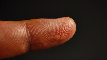Finger with friction ridges on dark background, macro view photo