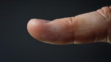 Finger with friction ridges on dark background, macro view photo