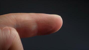 Finger with friction ridges on dark background, macro view photo