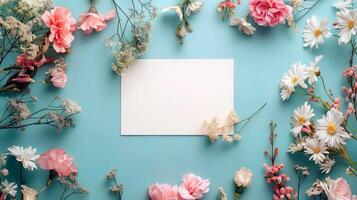Flat lay of beautiful flowers over green background and blank card for invitation. Mother's day, Valentine's day or wedding concept. Mock up template with space for text or product. photo