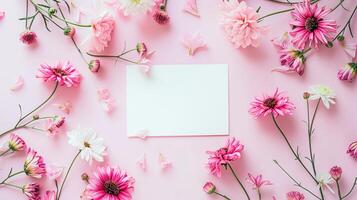 Flat lay of beautiful flowers over pink background and blank card for invitation. Mother's day, Valentine's day or wedding concept. Mock up template with space for text or product. photo