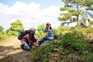 Asian tourists relax and sit looking into each other's eyes with love and concern for each other. Happy couple traveling in a tropical mountain forest. photo