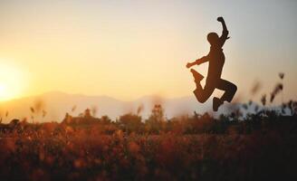 Silhouette of happiness and being free and relaxed in living life, success and working towards planned life goals. photo
