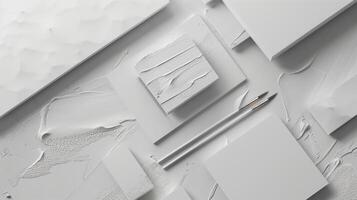 Flat lay of white art supplies mockup on textured surface. Minimalist and monochromatic workspace template advertising image. Paintbrushes, canvas mock up product photorealistic photo