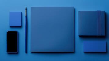 Flatlay of blue stationery mockup on monochromatic surface. Smartphone blank, blue square papers template advertising image. Elegant arrangement mock up products photorealistic photo