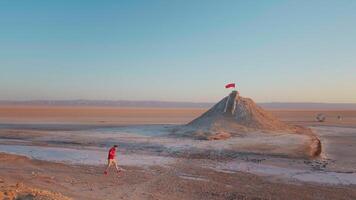 Large view of man climbing the sightseeing point of dried salted lake in sahara. video