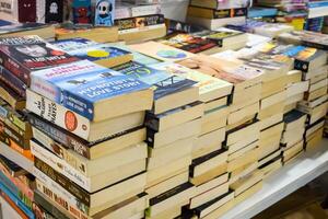 New Delhi, India, June 17 2024 - Variety of Books on shelf inside a book-stall at Delhi International Book Fair, Selection of books on display in Annual Book Fair at Bharat Mandapam complex photo