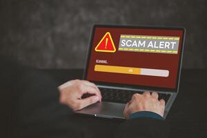 Laptop screen displaying scam alert warning. Highlights cybersecurity, online fraud, digital risk awareness. Suitable for tech security, internet safety topics. photo