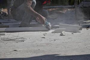 A worker is using a tool to cut cement rods. causing dust to permeate concept of safety at work photo