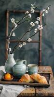 Japanese breakfast with croissants and cherry blossom branches in a vase photo