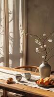 Japanese breakfast with aromatic crispy croissants, hot coffee and tangerines stands on a table decorated with a vase with cherry blossom branches photo
