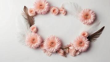 Ivory and peach flowers and feathers on a background, floral frame, copy space photo
