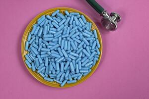 plate with medicine capsules and stethoscope photo