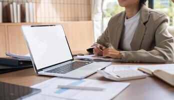 Business Team Collaborating and Taking Meeting Notes in a Modern Office Setting with Laptop and Documents photo