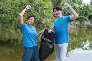 Enthusiastic Volunteer Couple Collecting Trash in Nature to Promote Environmental Conservation and Community Cleanliness photo