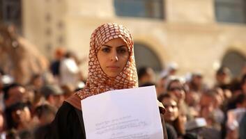 A group of Muslim women wearing hijabs is captured in a demonstration, symbolizing their collective struggle and advocacy for the rights of Muslims worldwide, emphasizing themes of photo