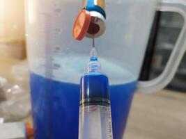 Mixing chicken vaccine medication with solvent, the process of making a dose of chicken vaccine spray medication. photo