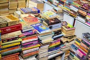 New Delhi, India, February 17 2024 - Variety of Books on shelf inside a book-stall at Delhi International Book Fair, Selection of books on display in Annual Book Fair at Bharat Mandapam complex photo