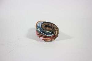 indonesian rupiah banknotes rolled into a tube and tied with a rubber band. Money roll isolated on a white background photo