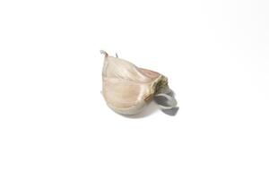 A piece of garlic isolated. Raw garlic with segments isolated on white background. photo