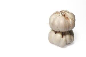 two garlic cloves stacked on top of each other. isolated background. white background. photo