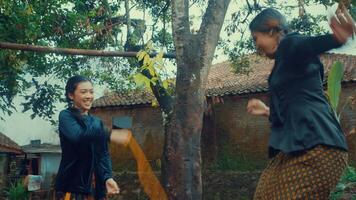 Women playing and laughing near a tree in a rustic setting video