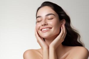 Beautiful woman with clean perfect skin and touching her face on white background photo