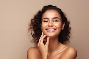 Beautiful woman with clean perfect skin and touching her face on beige background photo