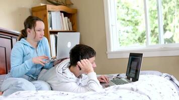 student helps pretty friend with red hair do homework sitting in library, use laptop, prepare new project, looking for new research topic, study together, using modern technologies video