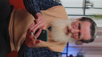 Senior grandfather at home use smartphone typing browsing, wow yes found out great big win celebrate video