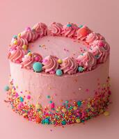 Pink cake decorated with colorful sprinkles photo