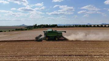 Side View of Combine Harvester in Wheat Field with Czech Highlands in Background video