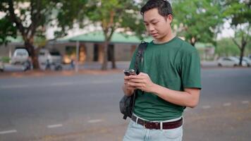 Smiling man cheats on phone while relaxing in summer park video