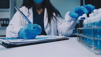 Scientists analyzing coronavirus study data and evaluating microscope. Health care researchers doing some research virus with dropper chemical testing and working in life science laboratory. video