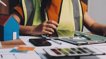 Selective focus, Asian female architect or engineer Currently considering materials for designing modern condominiums. Asian female architect or engineer Sit and analyze, design projects in the office video