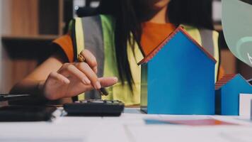 Selective focus, Asian female architect or engineer Currently considering materials for designing modern condominiums. Asian female architect or engineer Sit and analyze, design projects in the office video