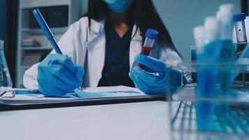 Scientists analyzing coronavirus study data and evaluating microscope. Health care researchers doing some research virus with dropper chemical testing and working in life science laboratory. video