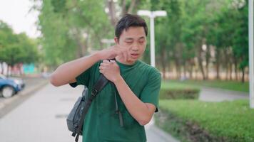 A man carries a backpack while walking on campus near the university building. Tired of the hot and refreshing weather video