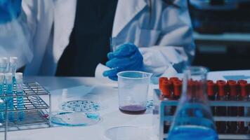 Scientists analyzing coronavirus study data and evaluating microscope. Health care researchers doing some research virus with dropper chemical testing and working in life science laboratory. video